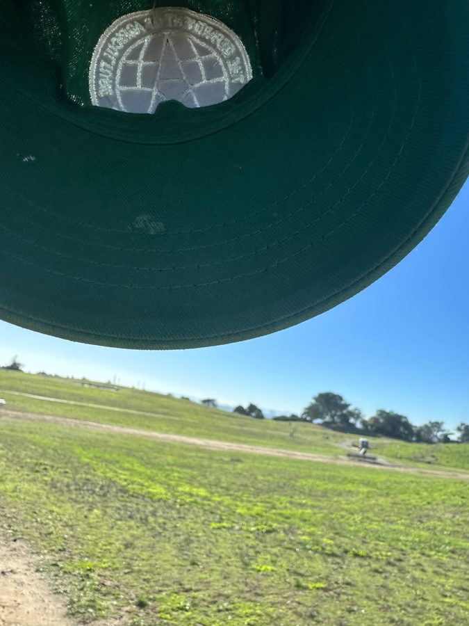 DOA hat held above an open grassy field