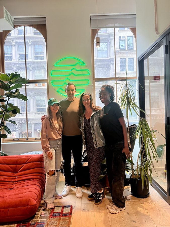 Four people at an Eco office, one in a DOA hat